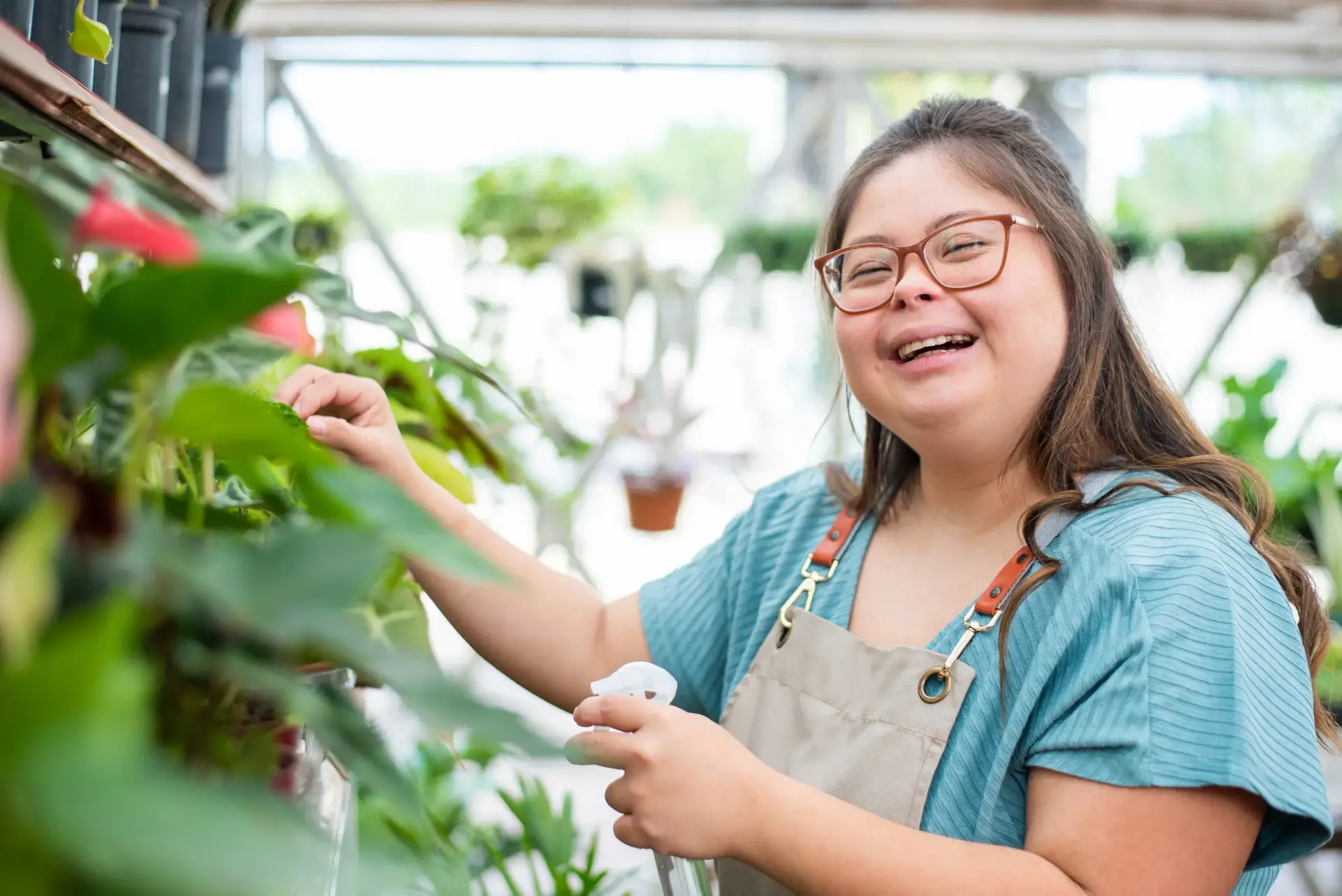 A young woman smiling while caring for plants